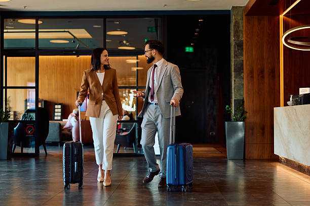 Couple with suitcases arriving in a hotel lobby